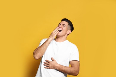 Photo of Handsome man laughing on yellow background. Funny joke