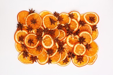 Photo of Dry orange slices and anise stars on white background, flat lay