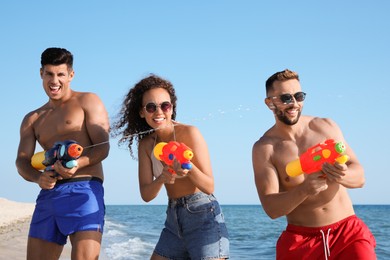 Photo of Friends with water guns having fun on beach