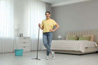 Photo of Woman cleaning floor with mop at home