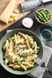 Photo of Delicious pasta with green peas served on grey table, top view