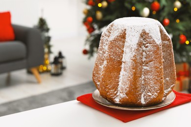 Photo of Traditional Italian pastry. Delicious Pandoro cake with powdered sugar on white table in room, space for text