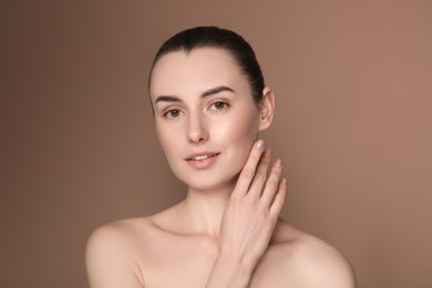 Photo of Portrait of beautiful young woman on brown background