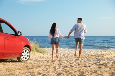 Photo of Lovely couple running on sandy beach. Summer trip