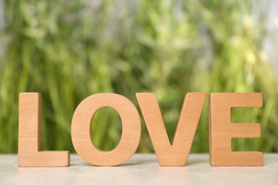 Photo of Word Love made of wooden letters on light table