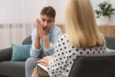 Photo of Psychologist working with teenage boy in office