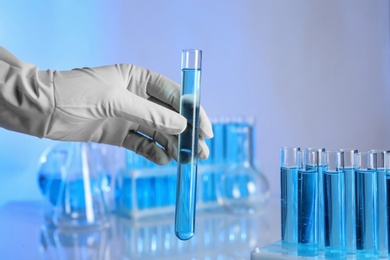 Photo of Scientist holding test tube with liquid for analysis in laboratory