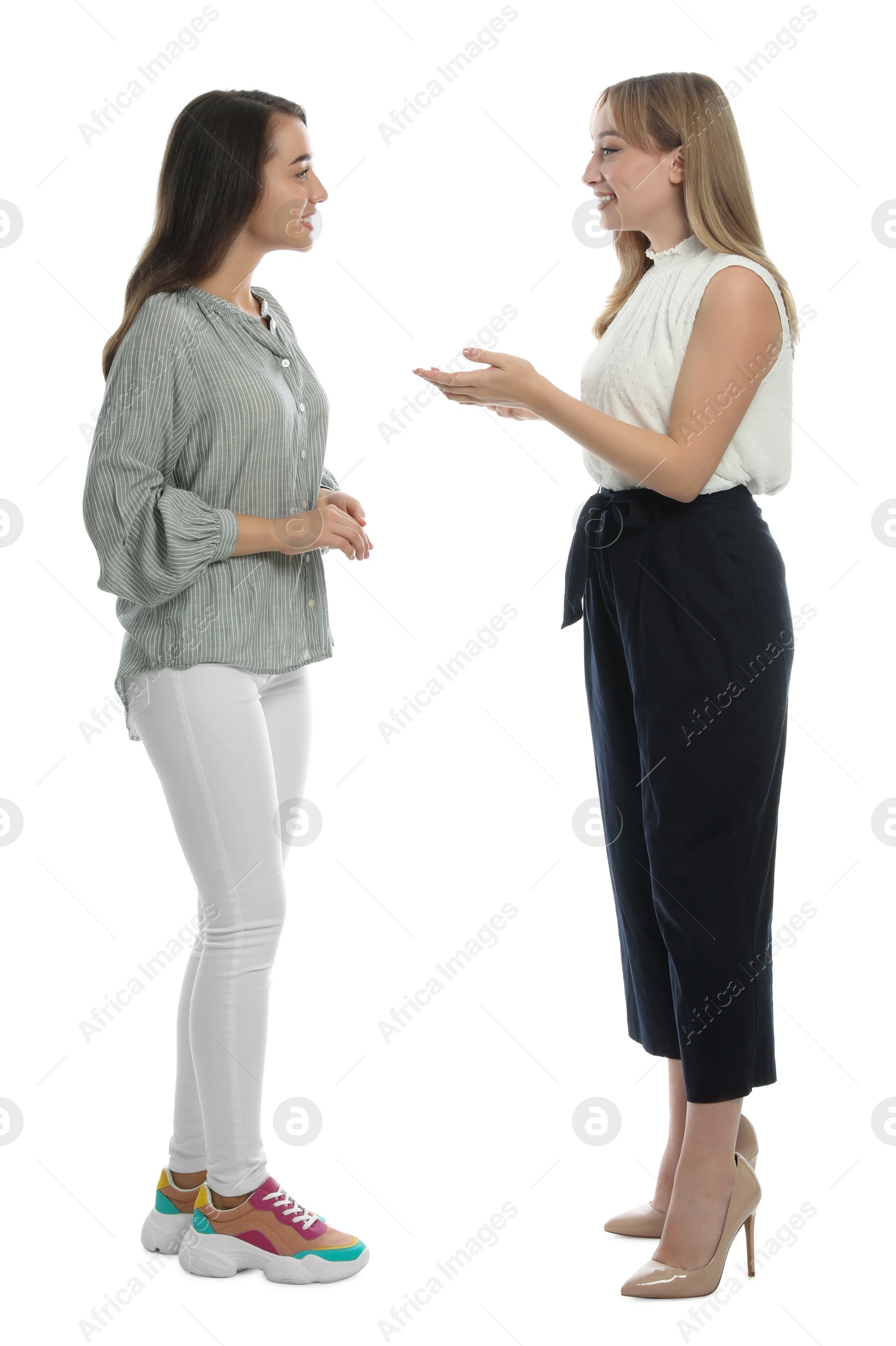 Photo of Young women in casual clothes talking on white background