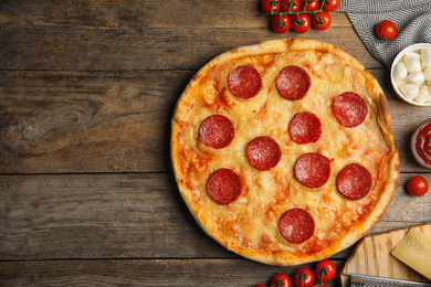 Photo of Flat lay composition with tasty pepperoni pizza on wooden table. Space for text