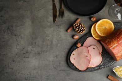 Photo of Flat lay composition with delicious ham on grey table, space for text. Christmas dinner