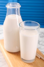 Photo of Glassware with tasty milk on white table, closeup