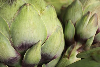 Photo of Fresh raw artichokes as background, closeup view