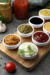 Photo of Many different sauces and products on grey table