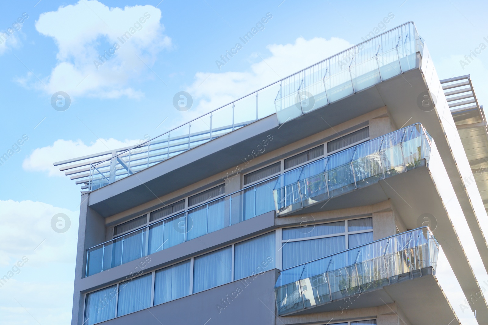 Photo of Exterior of beautiful residential building with balconies, low angle view