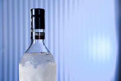 Photo of MYKOLAIV, UKRAINE - SEPTEMBER 23, 2019: Bottle of Finlandia vodka on blue background, closeup. Space for text