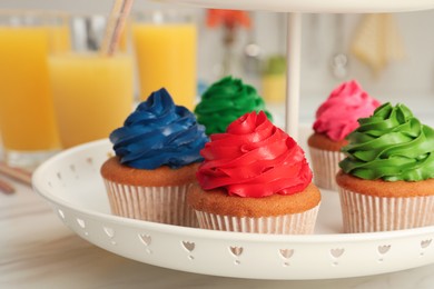 Delicious cupcakes with colorful cream on white table, closeup