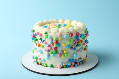 Photo of Cute bento cake with tasty cream on light blue background