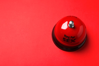 Photo of Sex bell on red background, above view. Space for text