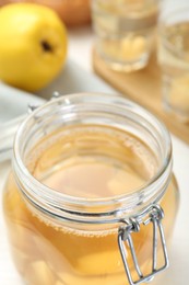 Photo of Delicious quince drink in glass jar on table, closeup