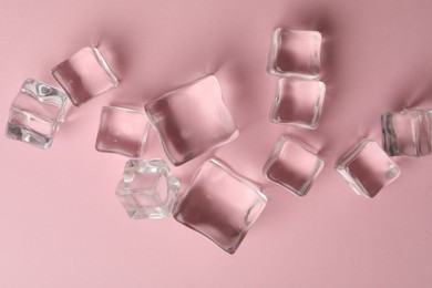 Photo of Crystal clear ice cubes on pink background, flat lay