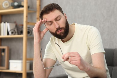 Photo of Overwhelmed man with glasses suffering at home
