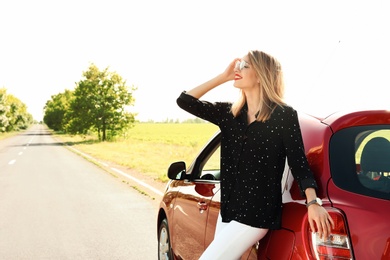 Photo of Young woman near car outdoors on sunny day