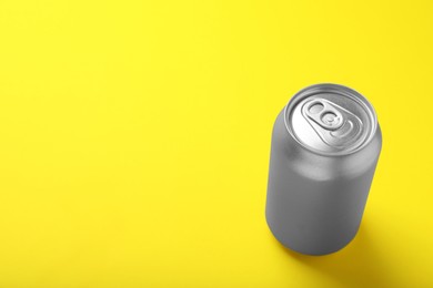 Photo of Can of energy drink on yellow background. Space for text