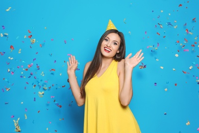 Photo of Young woman with party cap on color background. Birthday celebration