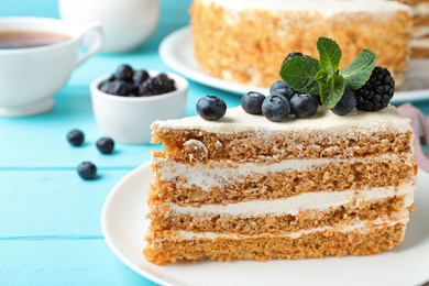 Photo of Delicious cake with blueberries on light blue table, closeup
