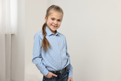 Photo of Cute little girl with braided hair indoors
