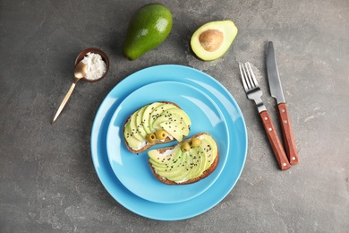 Photo of Crisp rye toasts with avocado, cream cheese and olives on plate, top view