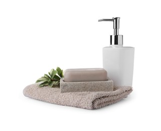 Photo of Dish with soap bar, dispenser and terry towel on white background