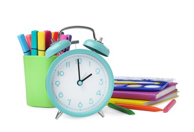 Photo of Turquoise alarm clock and different stationery on white background. School time