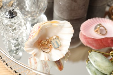 Photo of Beautiful jewelry and perfumes on table, closeup