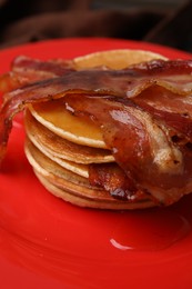 Photo of Delicious pancakes with bacon and honey on table, closeup