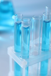 Photo of Test tubes with light blue liquid in laboratory, closeup