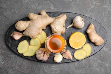 Photo of Fresh garlic and other natural cold remedies on grey table, top view
