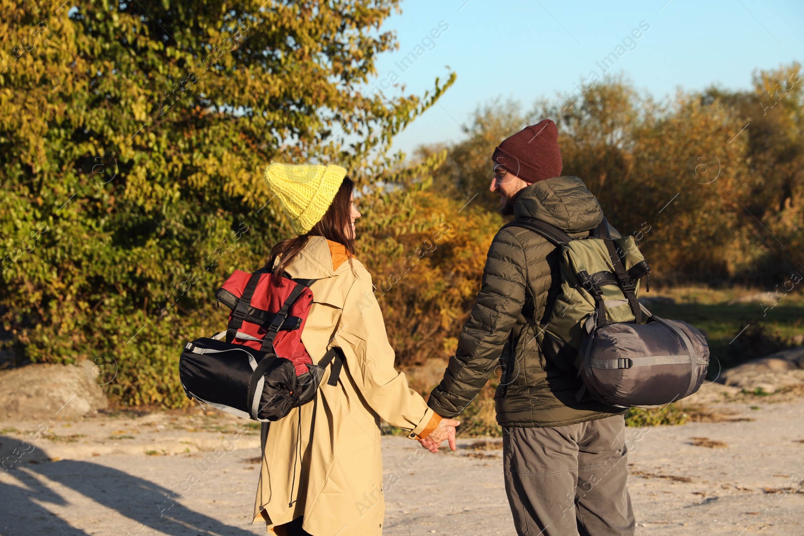 Photo of Couple of campers with backpacks and sleeping bags in wilderness