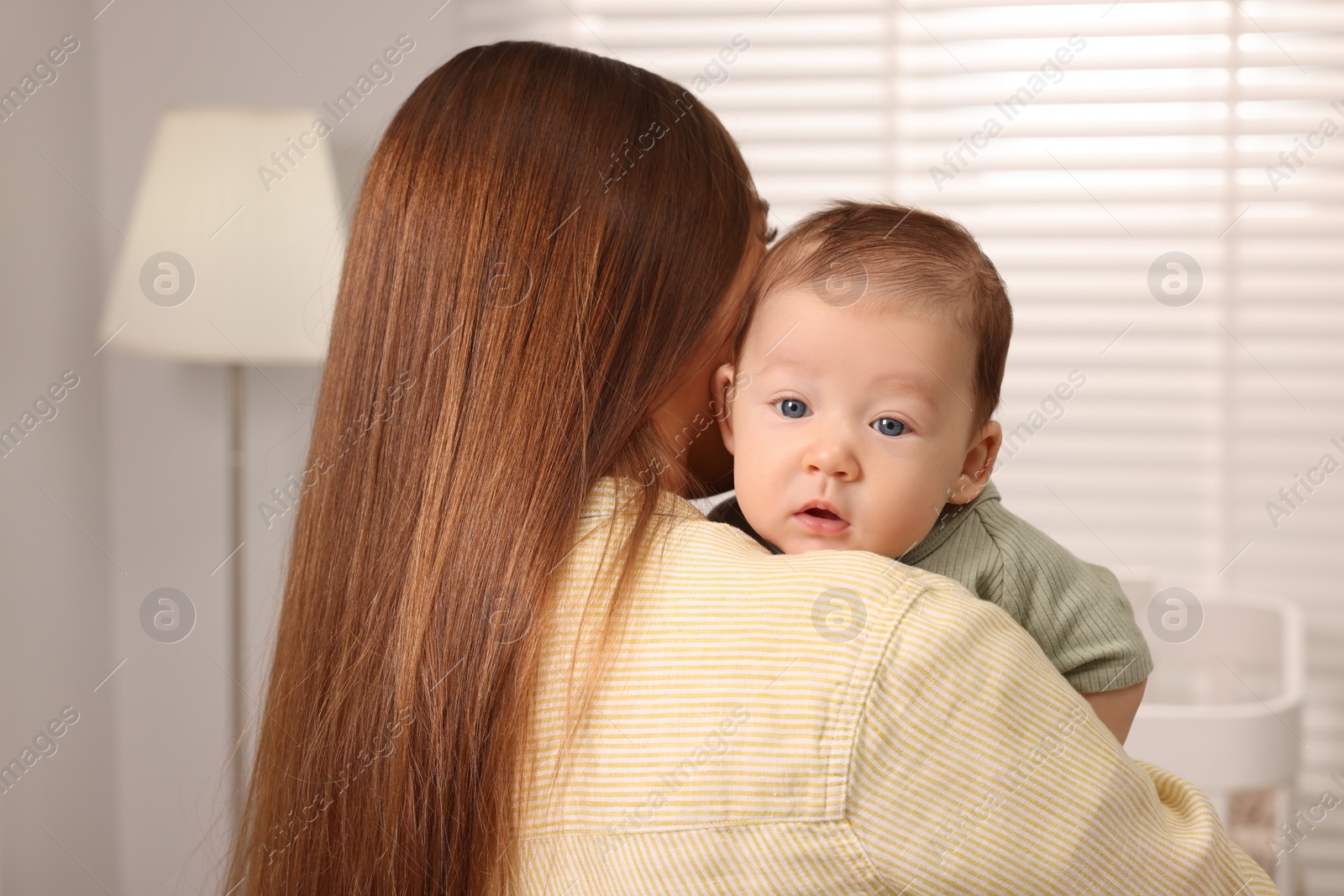 Photo of Mother holding her cute newborn baby at home