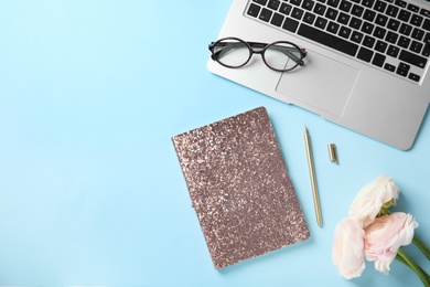 Flat lay composition with glittering notebook and laptop on color background. Space for text