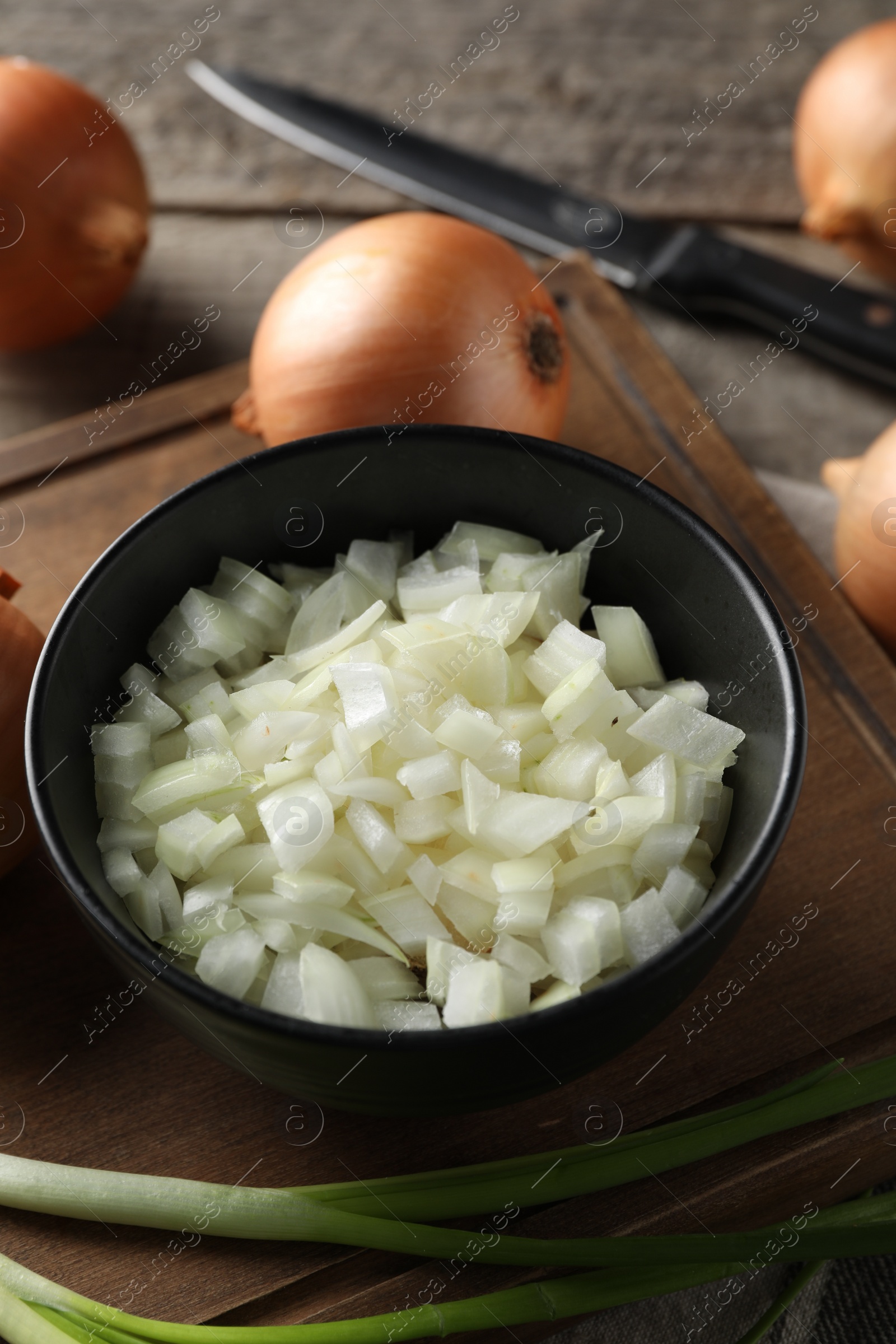 Photo of Whole and cut onion on wooden table, closeup