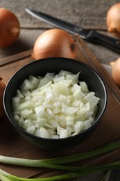 Photo of Whole and cut onion on wooden table, closeup