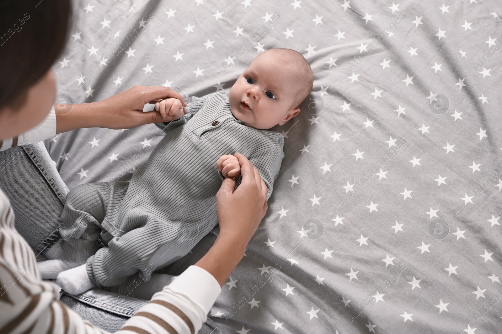 Photo of Mother and her little baby on bed, above view. Space for text