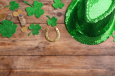 Photo of Leprechaun's hat and St. Patrick's day decor on wooden background, flat lay. Space for text