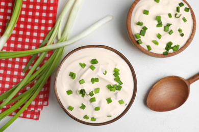 Photo of Fresh sour cream with onion on white table, flat lay