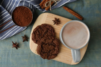 Photo of Composition with delicious hot cocoa drink and cookies on light blue wooden background, flat lay