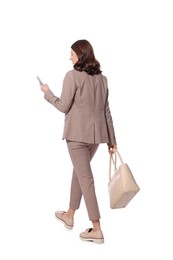 Photo of Businesswoman using smartphone while walking on white background