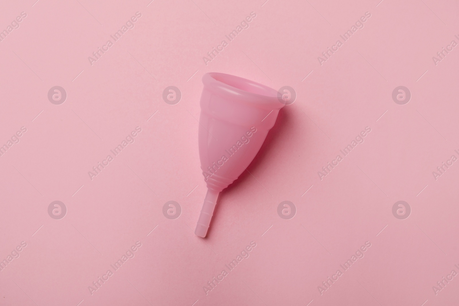 Photo of Menstrual cup on pink background, top view