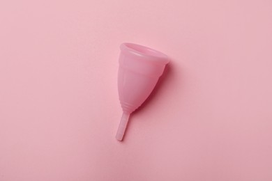 Menstrual cup on pink background, top view