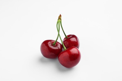 Photo of Three ripe sweet cherries on white background